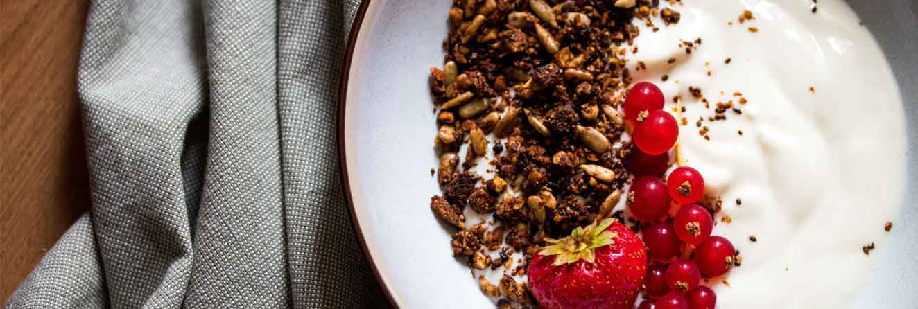 tigela de cereal com cereja e morango em cima da mesa
