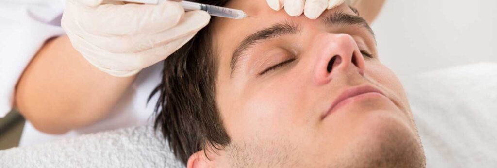 Homem deitado aplica botox na testa