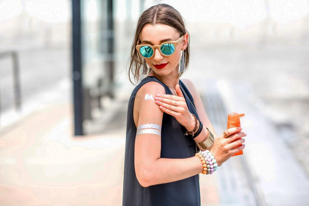 Foto de mulher aplicando protetor solar para curtir o carnaval.