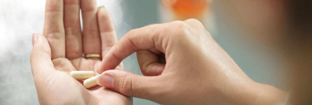 mão de mulher segura cápsulas de vitamina D