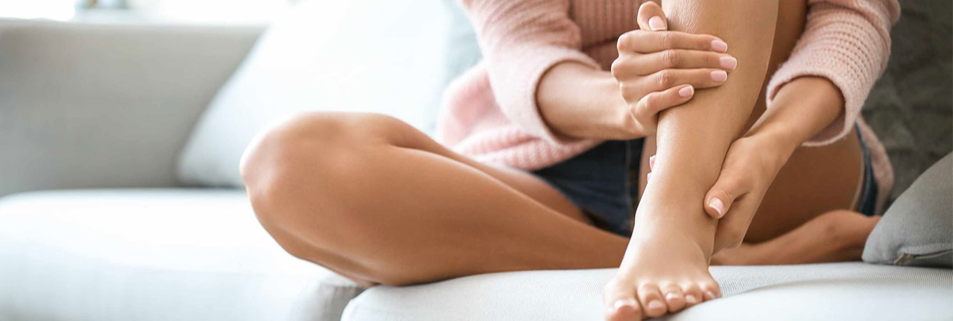 mulher sentada com as mãos na perna sem celulite